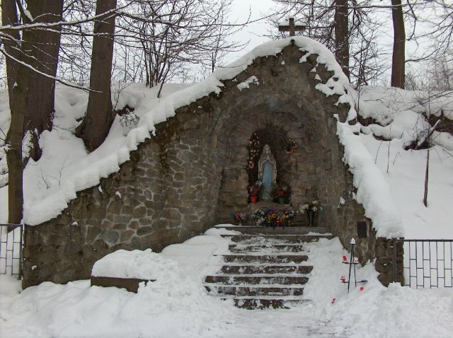 Kamienna grota maryjna w Rokicinach Podhalańskich w zimowej scenerii.