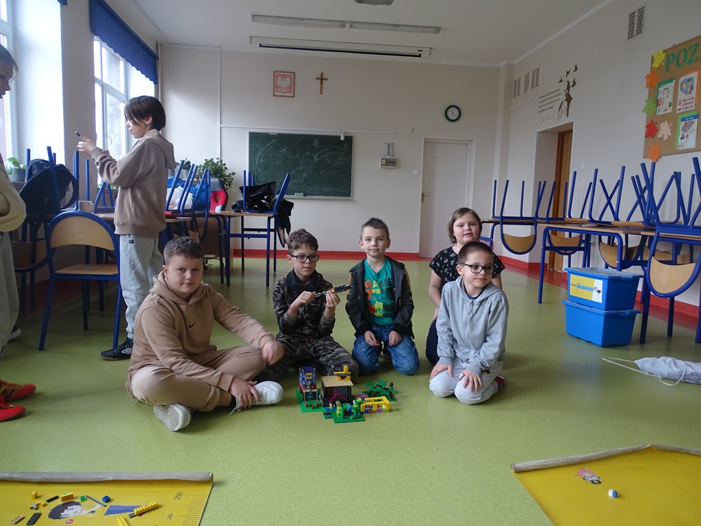 Zdjęcie przedstawia jedną z grup, która prezentuję swoją budowlę z klocków LEGO. 
