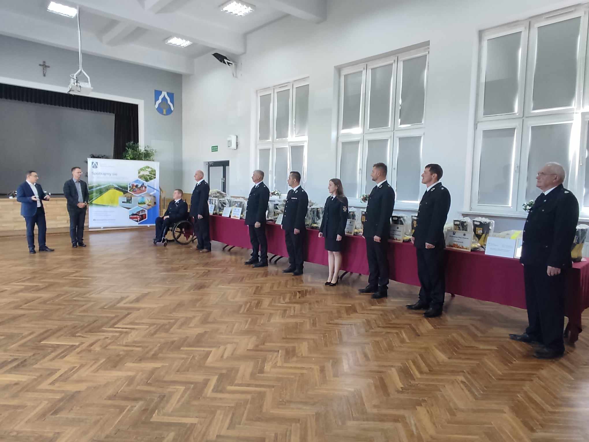 zdjęcie przedstawia od lewej Piotra Saka- Posła na Sejm RP, Tomasza Banka- Wójta Gminy Wietrzychowice oraz przedstawicieli poszczególnych jednostek OSP