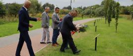 Delegacja powiatu podczas składania wiązanki przy tabliczce Dąb pamięci