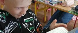Uczeń wrzuca kartę ze swoim głosem do urny wyborczej