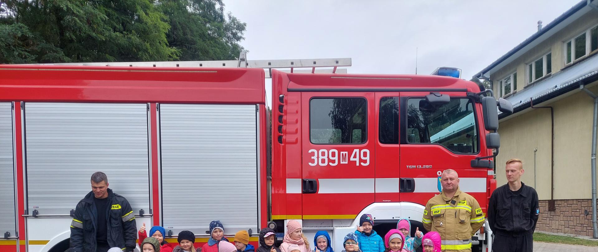 Dzieci z oddziału przedszkolnego na wspólnym zdjęciu ze strażakami.