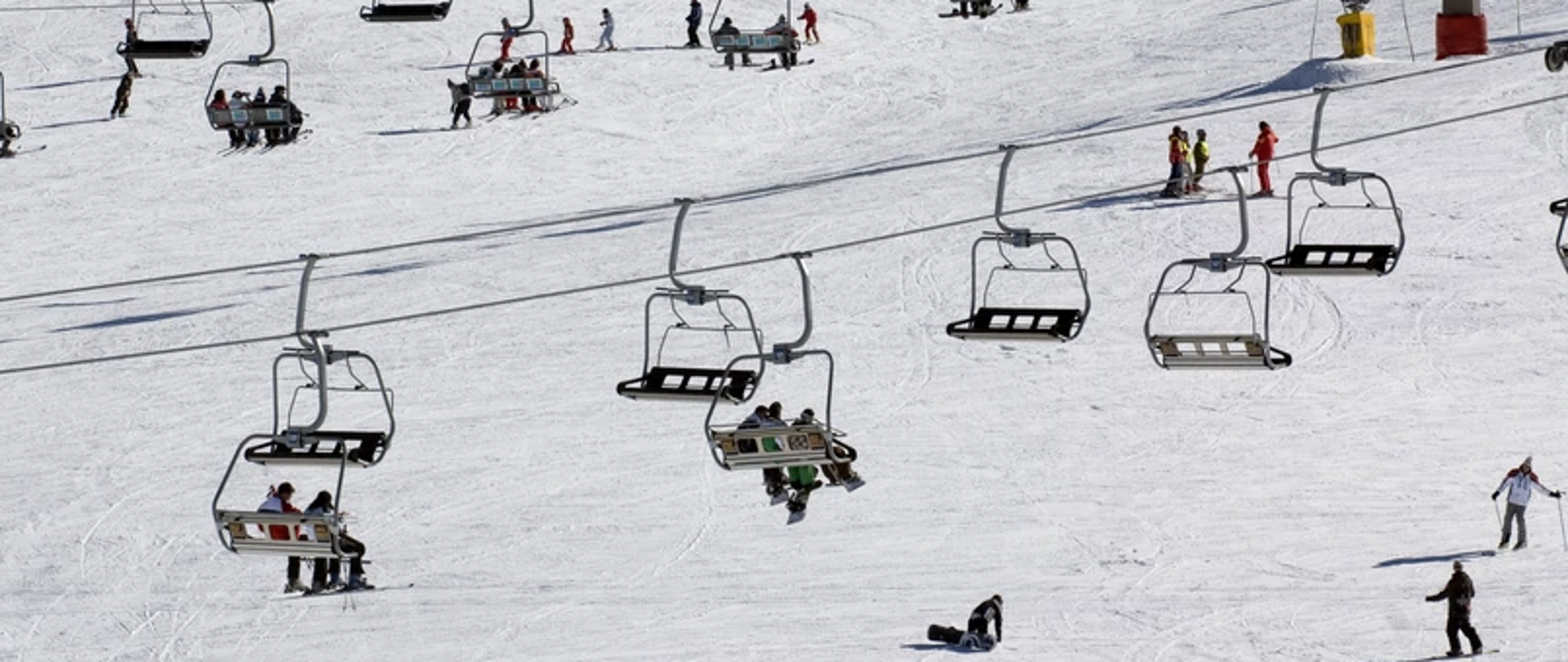 Zdjęcie przedstawia wyciąg narciarski na tle ośnieżonego stoku