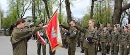 Moment składania ślubowania - przed sztandarem szkoły, stoi czterech uczniów Oddziału Przygotowania Wojskowego