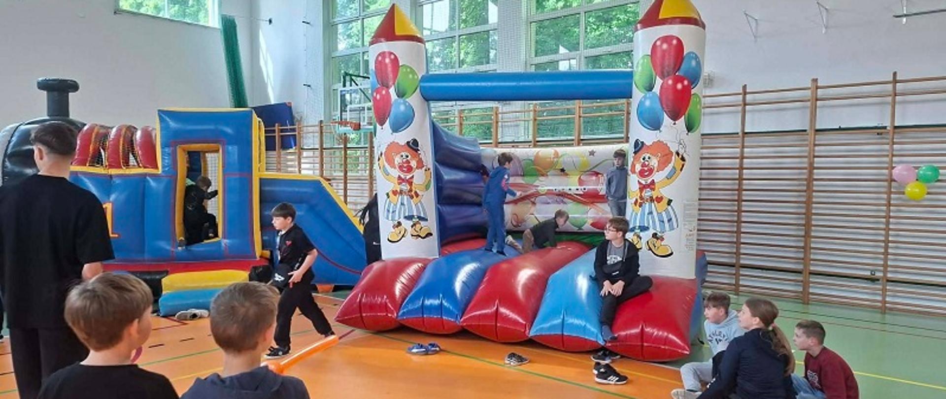 dzieci stojące przy dmuchanej zjeżdżalni