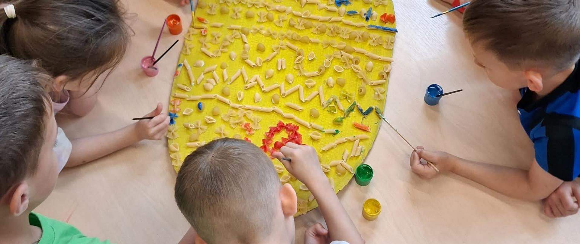 Wspólne tworzenie wielkanocnej pisanki przez przedszkolaków