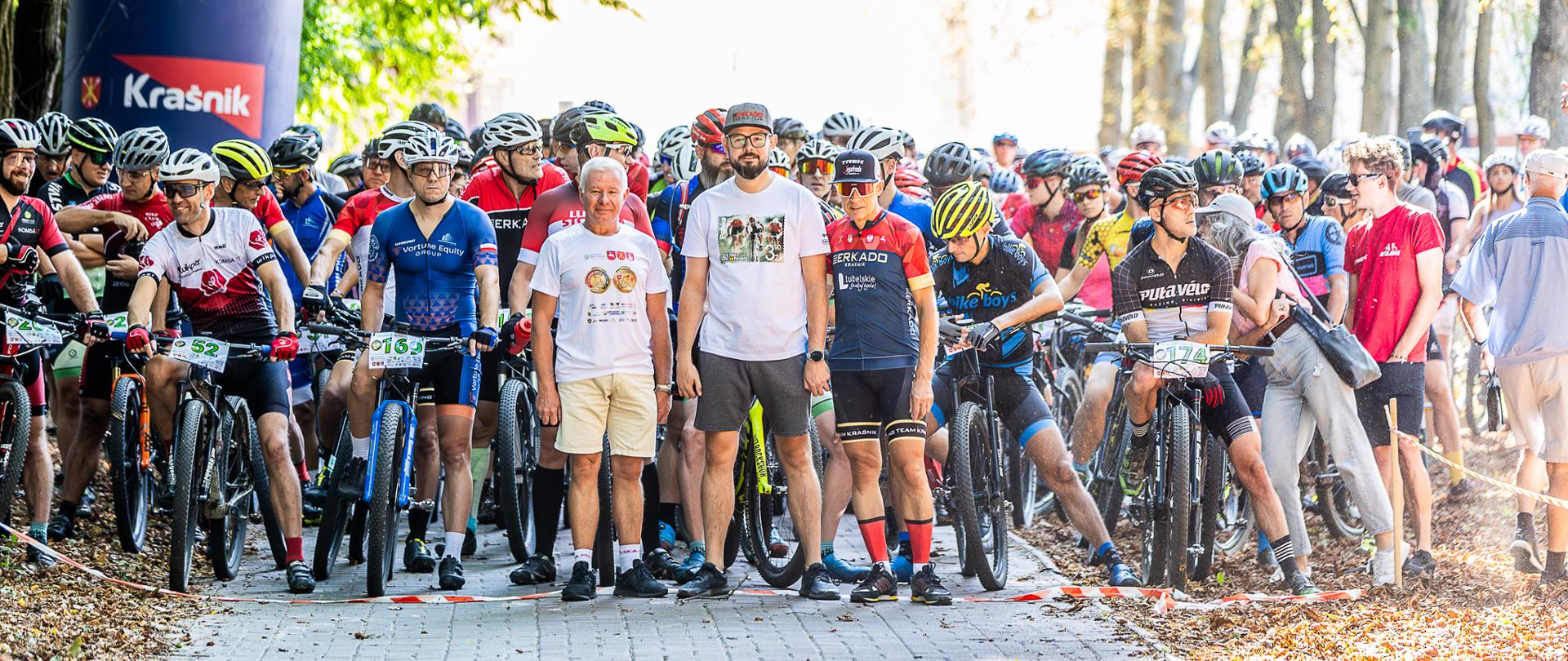 Zawodnicy na rowerach przed startem wyścigu głównego. Na pierwszym planie stoją członkowie Zarządu Klubu Sportowego "Racing Team Kraśnik": od lewej: Andrzej Rolla, Krzysztof Grzegorczyk i Jerzy Rostek