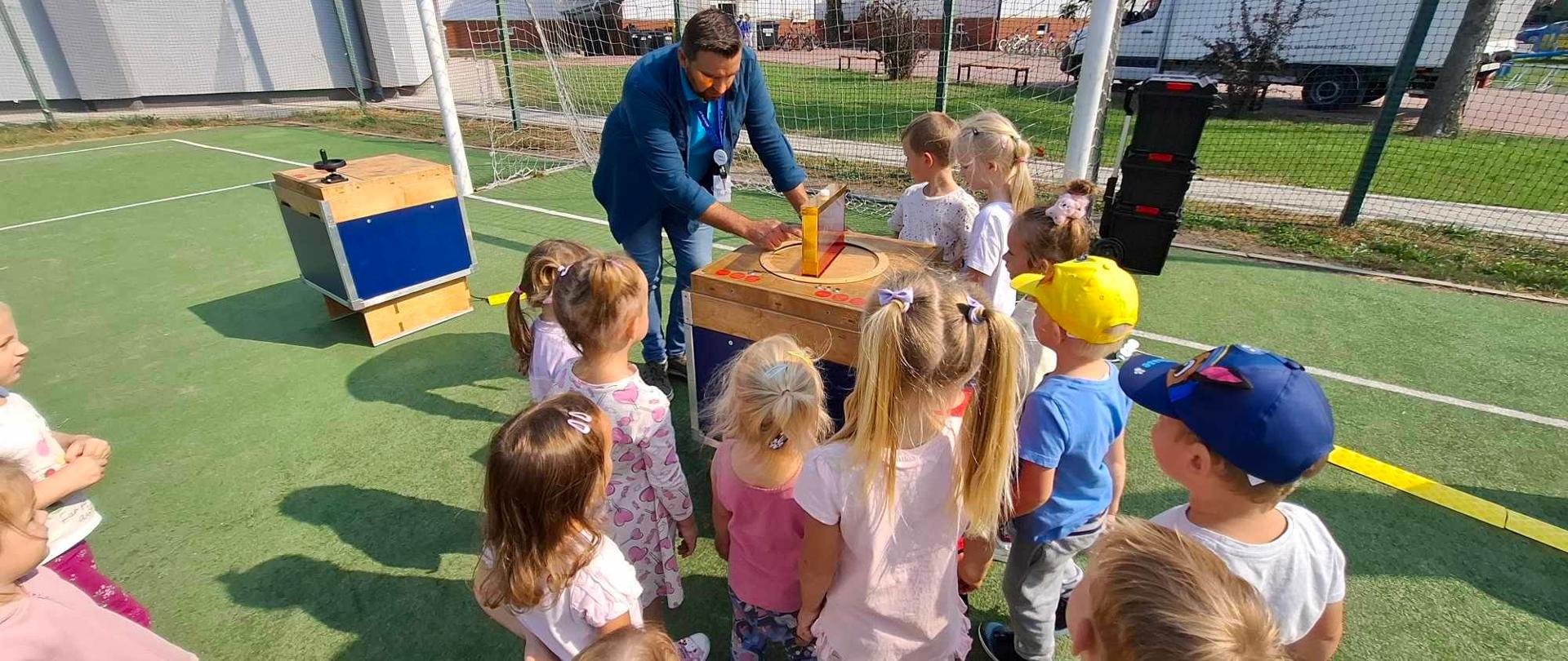 Dzieci na boisku szkolnym oglądają eksponaty Podkarpackiego Centrum Nauki „Łukasiewicz”