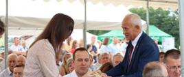 Poseł na Sejm RP - Krzysztof Tchórzewski częstujący chlebem dożynkowym