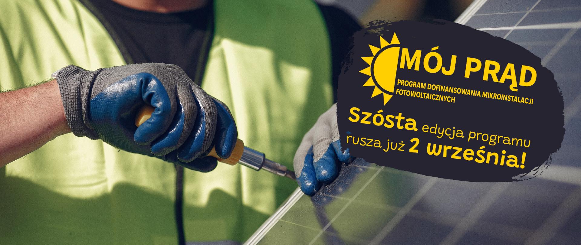 Ręka trzymająca śrubokręt wkręcający śrubkę do panelu fotowoltaicznego.