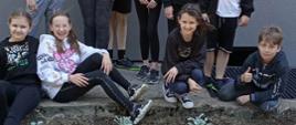 Dzieci sadzą kwiaty przed szkołą