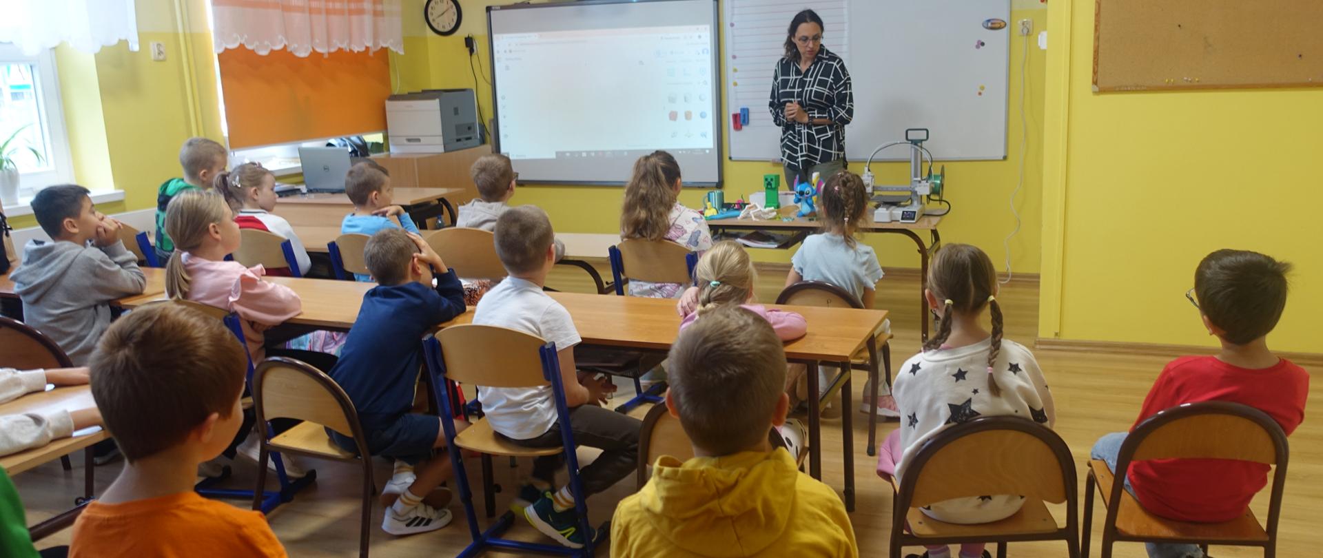 Uczniowie klas młodszych w sali lekcyjnej uczestniczą w zajęciach pokazowych