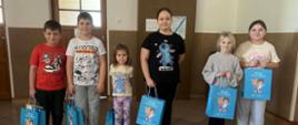 Na zdjęciu znajduje się sześcioro uczniów nagrodzonych w konkursie fotograficznym. Każdy z nich trzyma w dłoni niebieską torebkę z nagrodą.