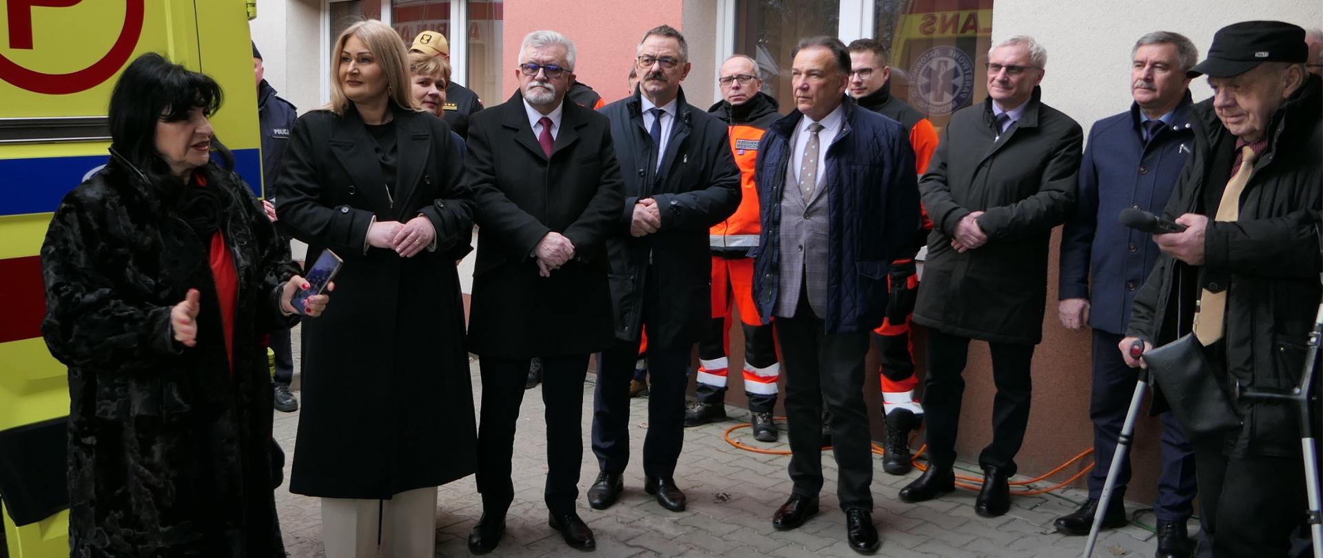 Uczestnicy wydarzenia stoją przy nowej karetce.