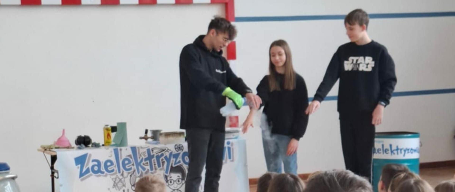 Uczniowie biorący udział w wykonywanym doświadczeniu