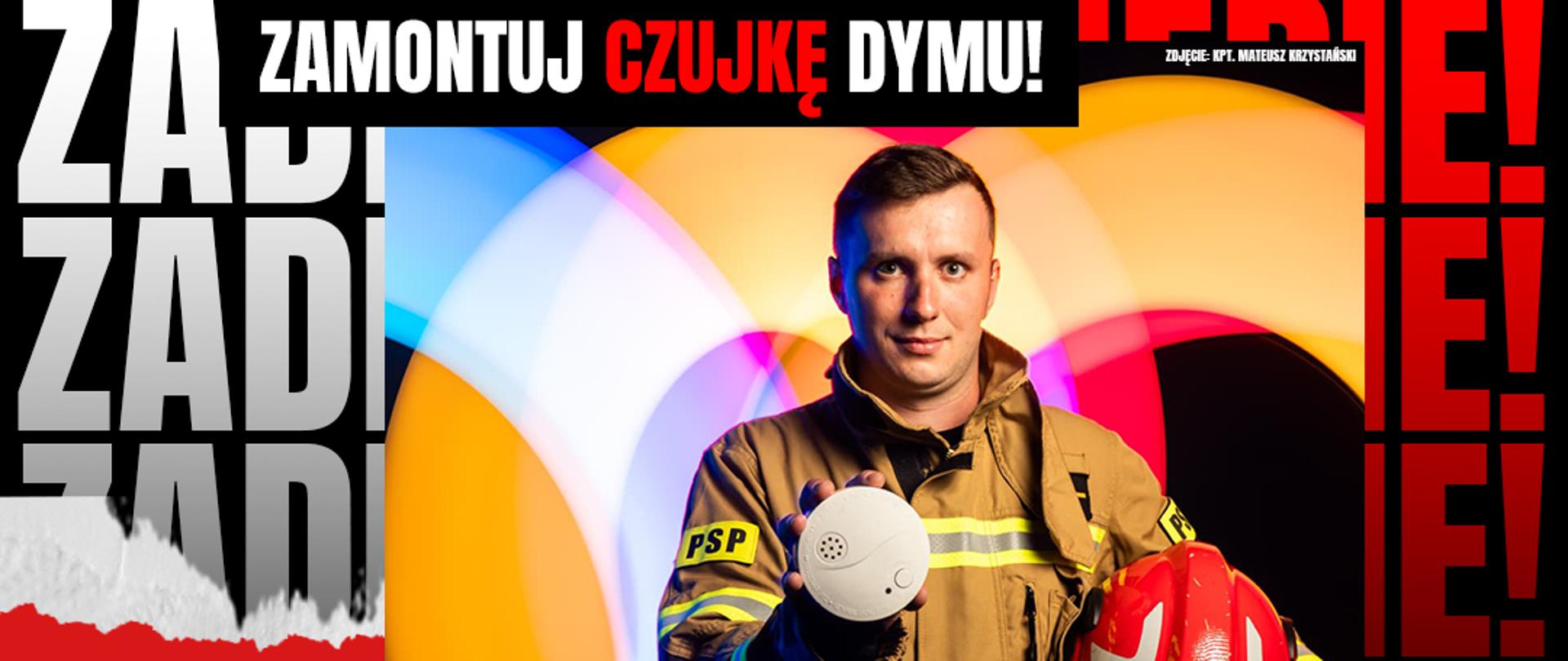 Strażak w mundurze trzyma czujkę dymu i hełm. Napis: „Zadbaj o siebie! Zamontuj czujkę dymu. Większość śmiertelnych pożarów powstaje w nocy.”