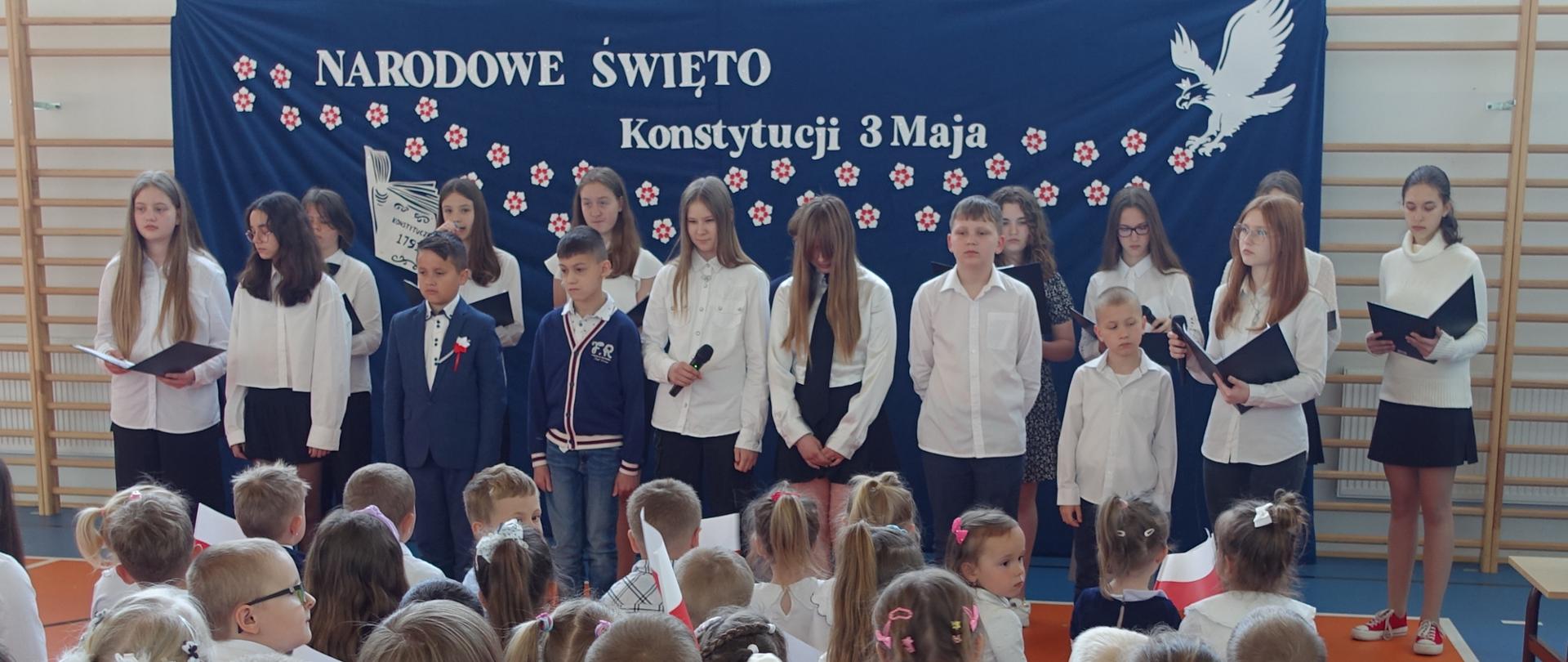 Uczniowie klas starszych na tle dekoracji - Narodowe Święto Konstytucji 3 Maja
