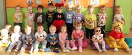 Na zdjęciu są dzieci z grupy Motylki. W tle widnieje napis " Dzień Postaci z Bajek" oraz ilustracje przedstawiające bajkowe postacie.