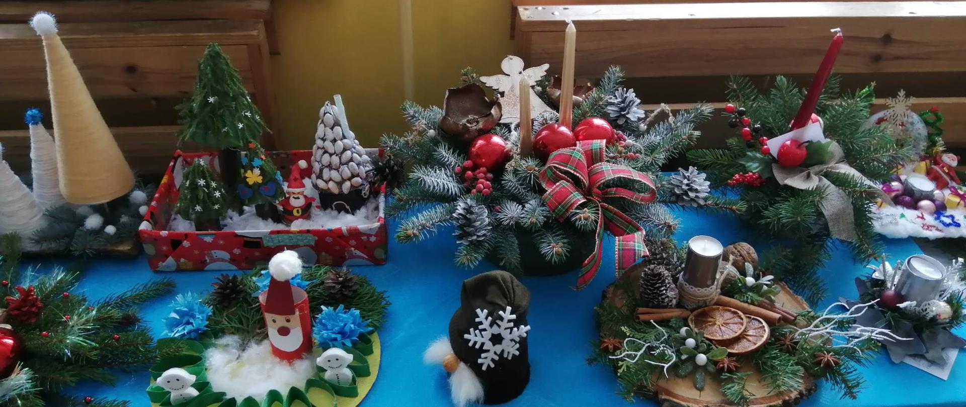 Na zdjęciu stół przykryty obrusem, a na nim widać różne formy stroików świątecznych przesłanych jako prace konkursowe.