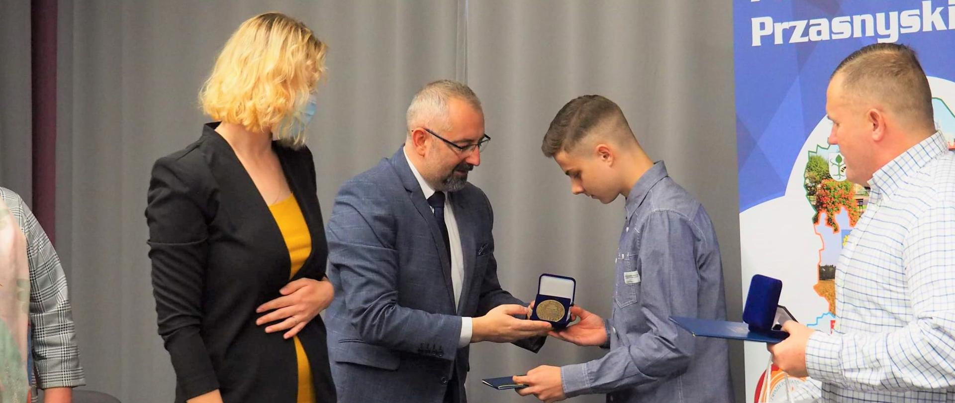 Zdjęcie wykonano podczas 50 Sesji Rady Powiatu Przasnyskiego na sali konferencyjnej w Centrum Aktywizacji Biznesu w budynku Starostwa Powiatowego w Przasnyszu. Fotografia przedstawia od lewej: Przewodniczącą Rady Katarzynę Wróblewską, Starostę Krzysztofa Bieńkowskiego, Jakuba Bońkowskiego, Cezarego Pykałę