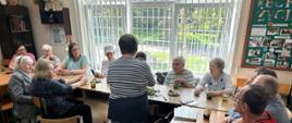 Uczestnicy warsztatów w trakcie zajęć - siedzą przy stole, poznają zioła