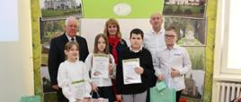 Na zdjęciu na ściance promocyjnej Powiatu Sokołowskiego widzimy laureatów konkursu w kategorii szkoły podstawowe klasy V-VIII. wraz z członkiem Zarządu Powiatu Sokołowskiego Ewa Olszewska oraz wiceprzewodniczący Jerzy Strzała oraz Wojciech Jańczuk.
