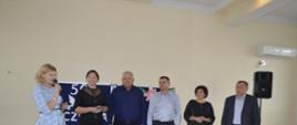 Pięcioro delegatów z Gromad na Ukrainie z Wójt Gminy z tablicą w tle