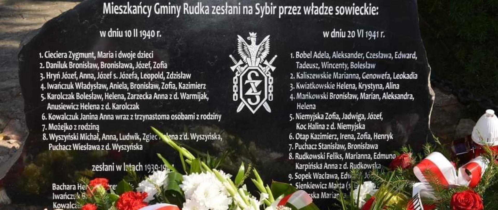 kamień z tablicą koloru czarnego z wypisanymi białymi literami imionami i nazwiskami mieszkańców Rudki wywiezionych na Sybir
