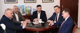 Delegacja gości rozmawia przy okrągłym stole w gabinecie Starosty Sokołowskiego.