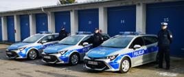Nowe radiowozy w służbie Powiatowej Komendy Policji w Przasnyszu. Na zdjęciu trzech policjantów pozuje obok trzech nowych radiowozów.