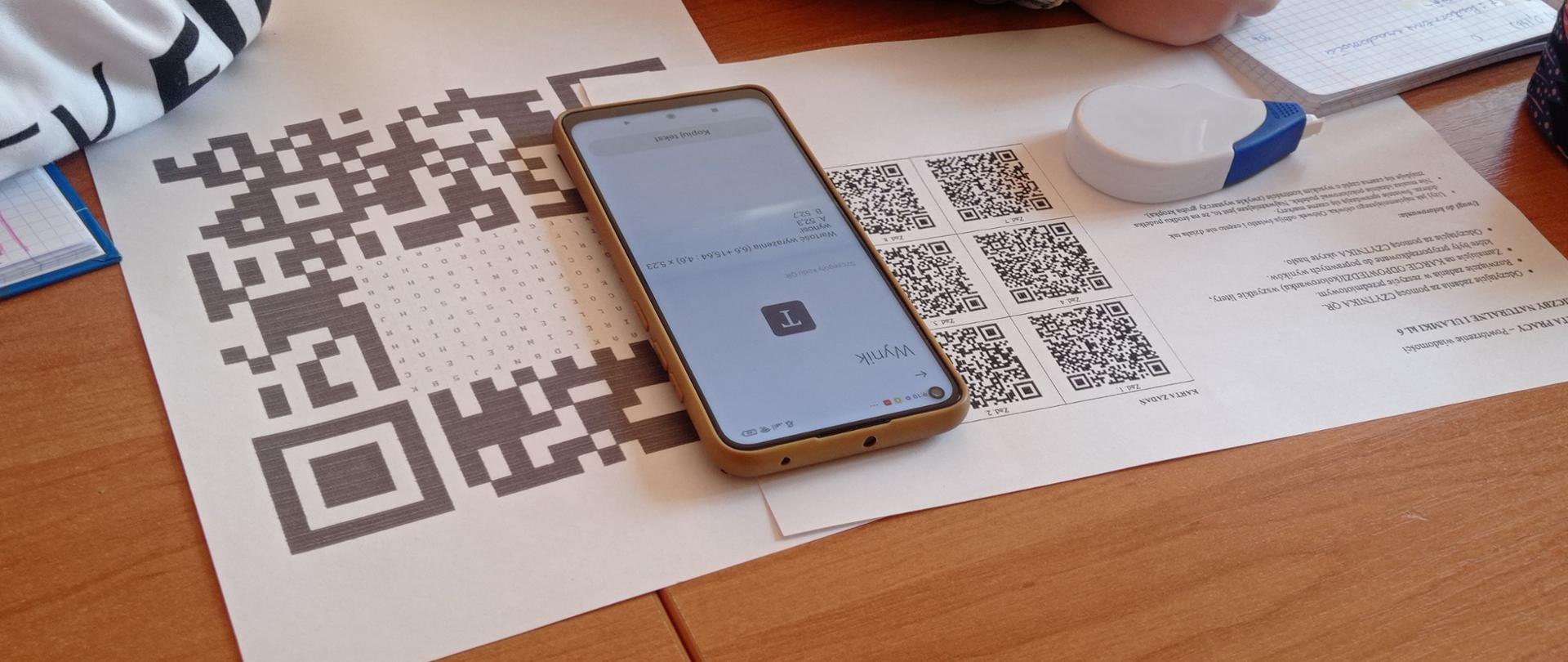 Telefon komórkowy oraz karty pracy.
