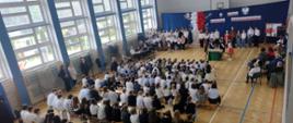 Uczniowie i nauczyciele oglądają uroczystą akademię