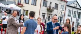 Starosta Powiatu Proszowickiego oraz Burmistrz Gminy i Miasta Proszowice wręczają medale jedym ze zwycięzców IX Biegu Proszowickiego im. Jana Marynowskiego 