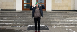 Olek pozuje przed budynkiem Akademii Wychowania Fizycznego w Warszawie