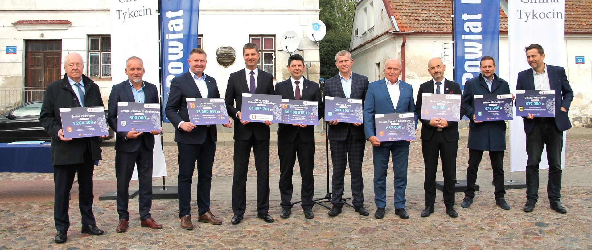 Wspólne zdjęcie samorządowców na tle kamienicy