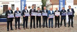 Wspólne zdjęcie samorządowców na tle kamienicy