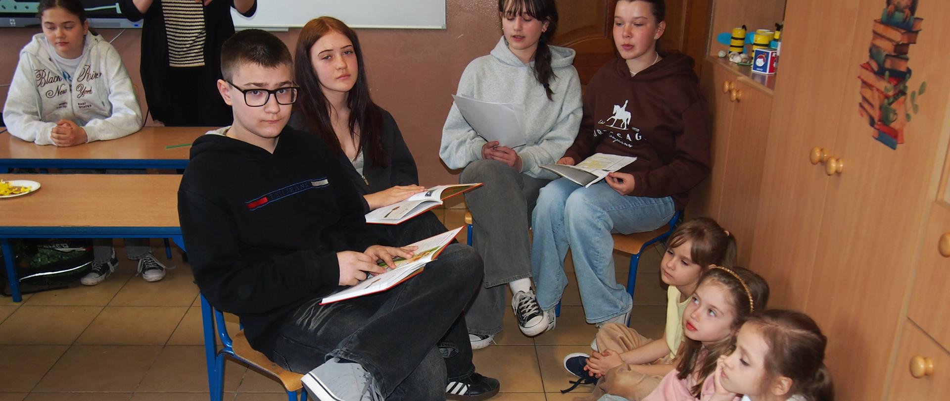 uczniowie klas starszych czytają swoim młodszym kolegom 
