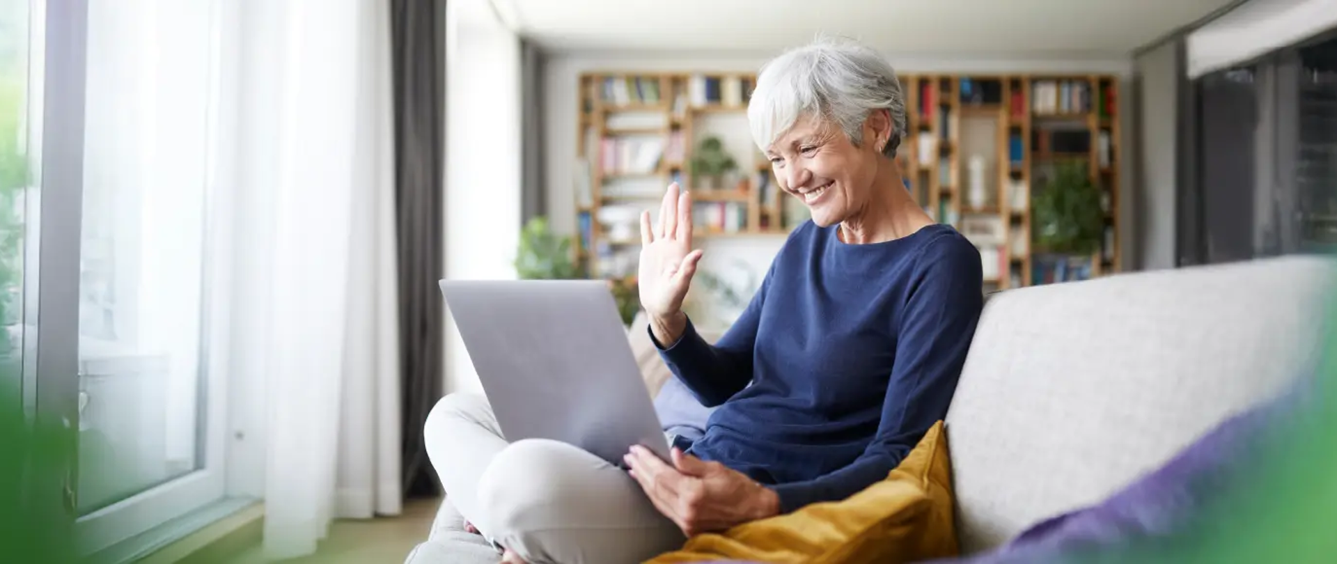 Osoba 60+ trzymająca laptop
