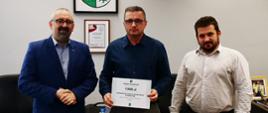 Jednorożecki Klub Badmintona „BadKurp” otrzymał dofinansowanie na reprezentowanie Powiatu Przasnyskiego w badmintonie. Zdjęcie wykonane w gabinecie Starosty w Przasnyszu. Po lewej Starosta Przasnyski Krzysztof Bieńkowski, w środku przedstawiciel "Badkurp", po prawej Etatowy Członek Zarządu Powiatu Paweł Mostowy.