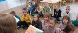 uczniowie starszych klas czytają bajki przedszkolakom podczas tygodnia książki