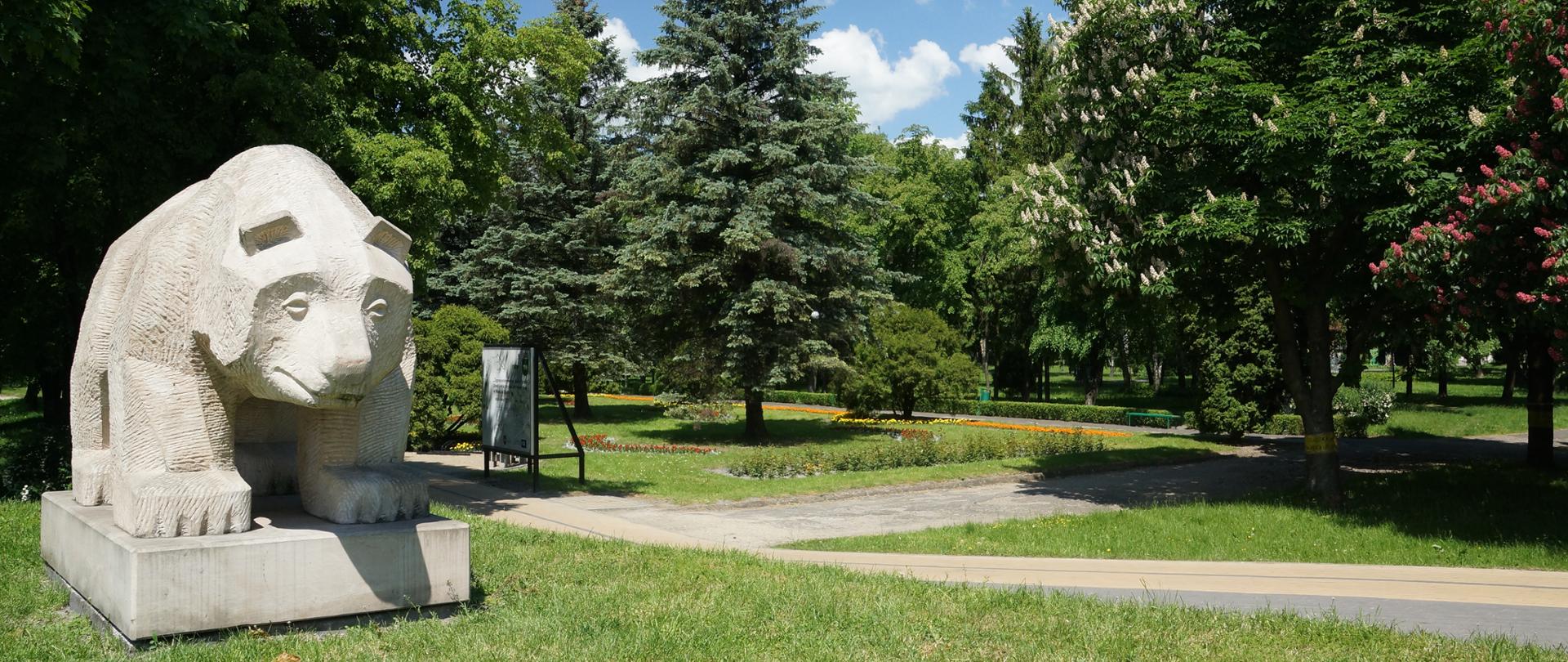 park, zielone drzewa, pomnik niedźwiedzia 