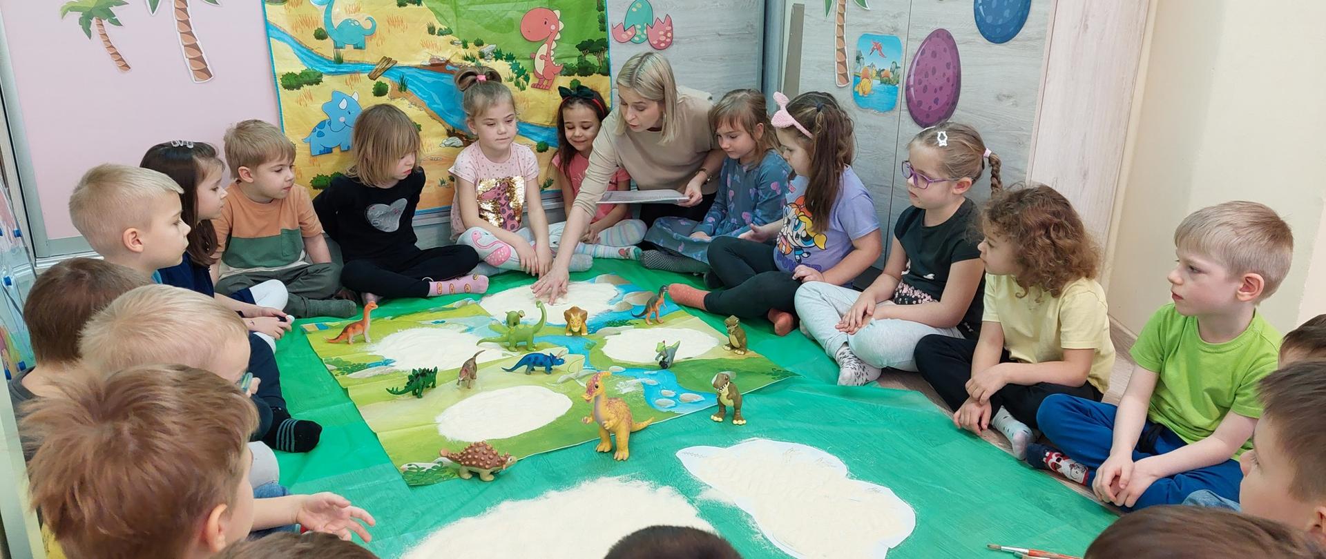 Nauczycielka i dzieci podczas zajęć o dinozaurami
