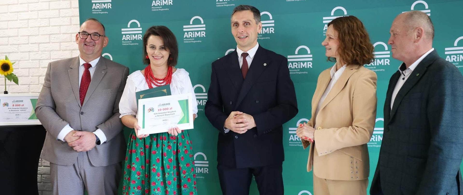 Laureatka prezentuje otrzymany czek na kwotę 8 000 zł podczas uroczystego spotkania z przedstawicielami ARiMR.