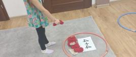 Dziewczynka rzuca woreczek do hula hop