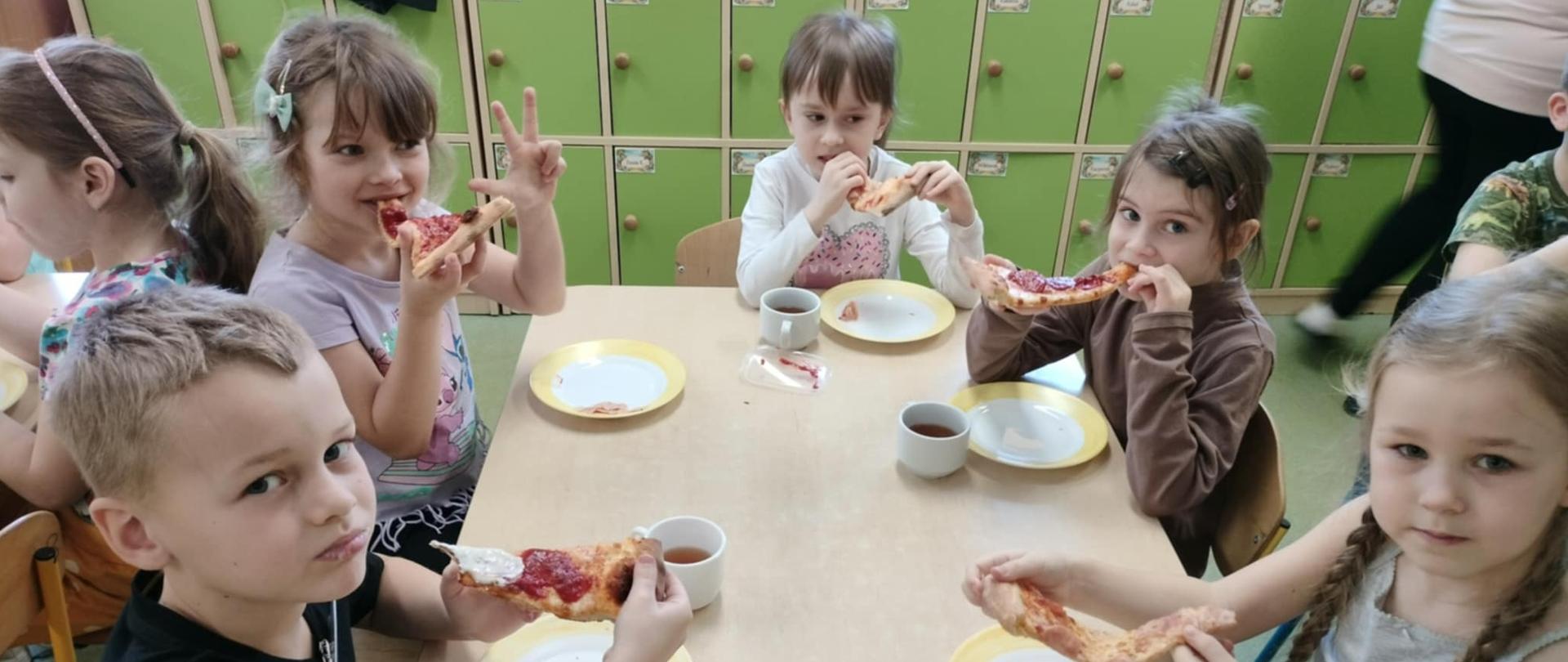 Dzieci jedzące pizzę
