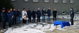 Samorządy Powiatu Przasnyskiego wsparły Powiatową Komendę Policji w Przasnyszu w pozyskaniu trzech nowych radiowozów. Na zdjęciu samorządowcy, policjanci i katolicki duchowny przygotowują się do poświęcenia nowych radiowozów.