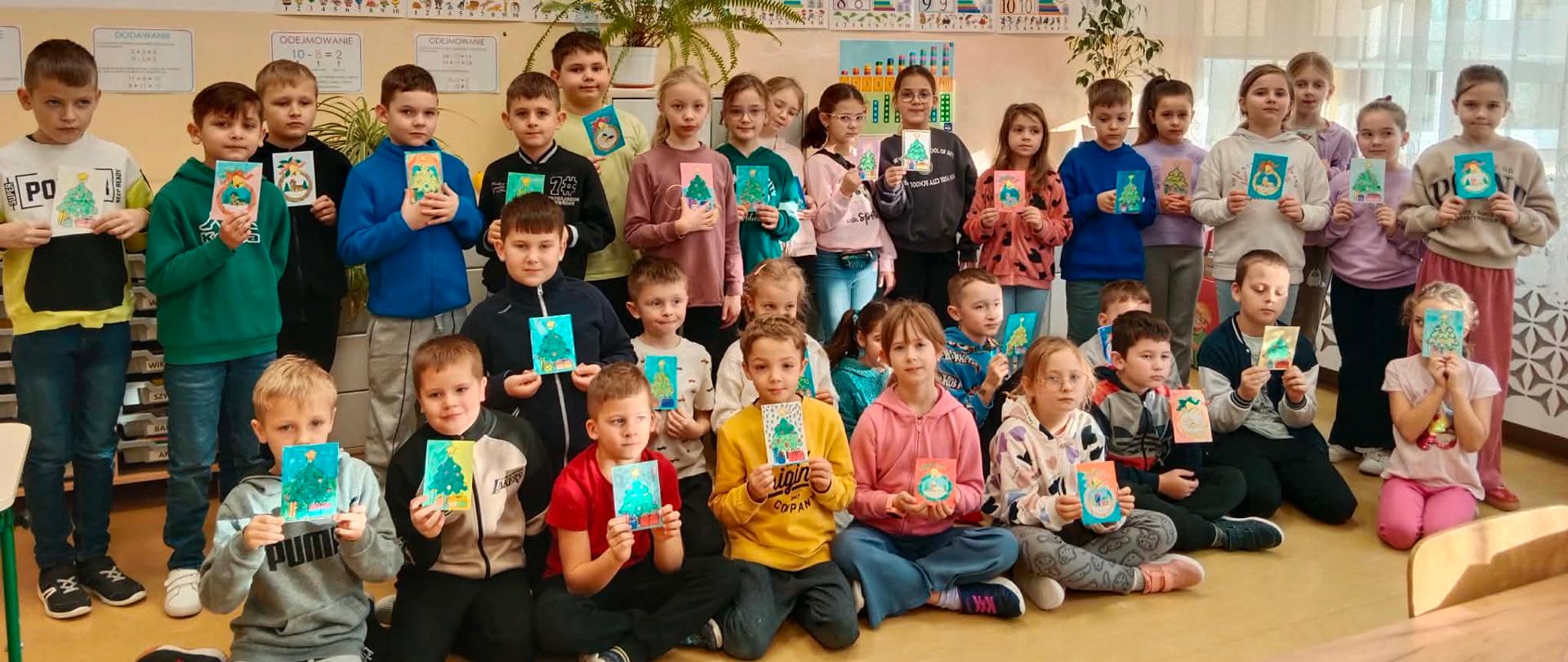 Uczniowie klas drugich z wykonanymi kartkami dla bohaterów.