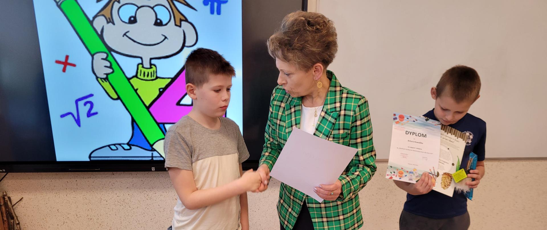 Pani Dyrektor gratuluje uczniom nagrodzonym w konkursie.