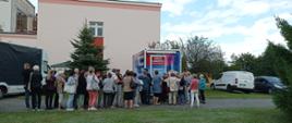 Zdjęcie wykonane podczas Festynu Profilaktyczno Zdrowotnego w ogrodach przasnyskiego szpitala. Fotografia przedstawia kolejkę do wykonania badania gęstości kości w osteobusie.