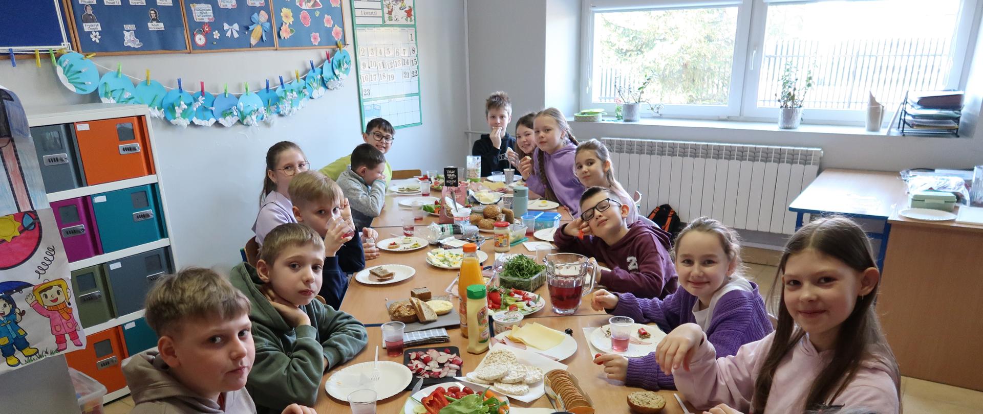 uczniowie wspólnie jedzą drugie śniadanie